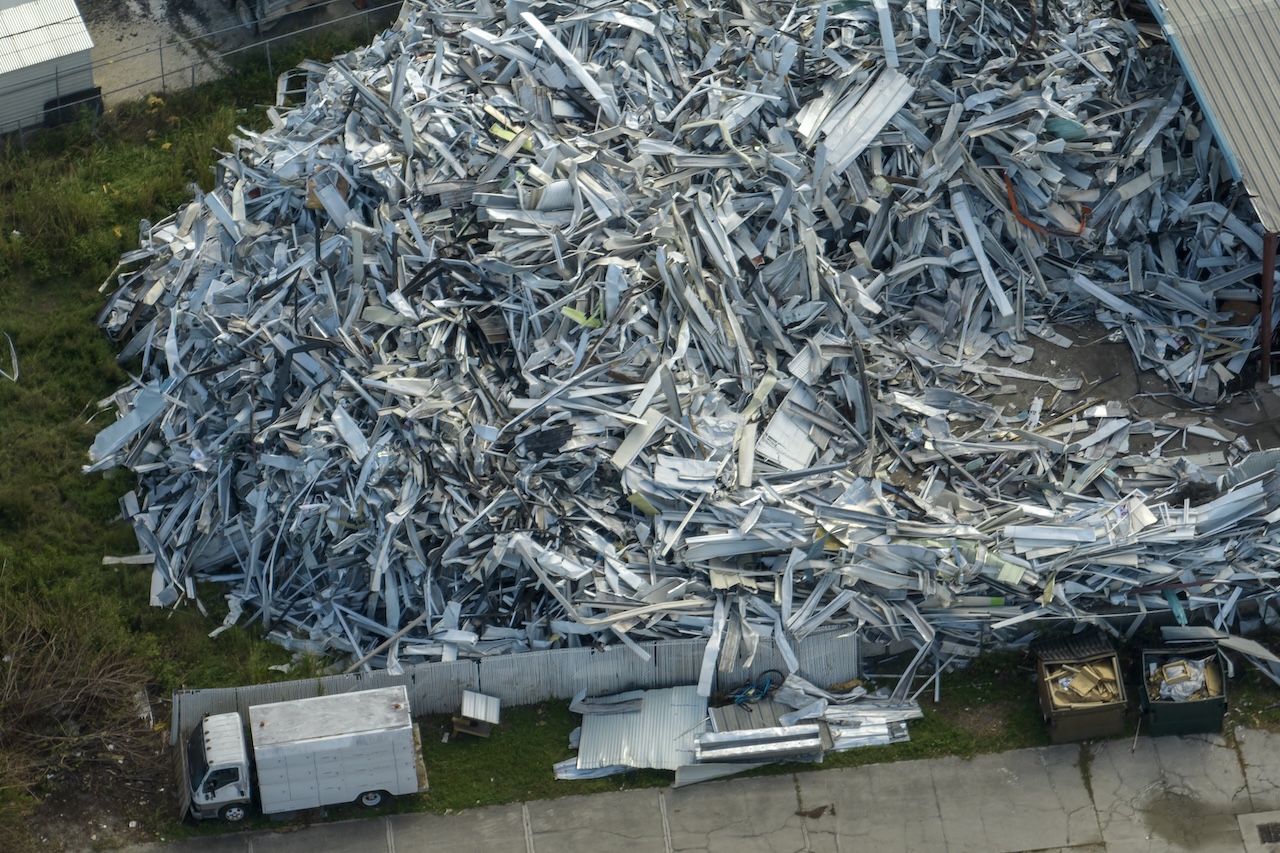 Aerial view of large pile of scrap aluminum metal from broken houses after hurricane Ian swept through Florida. Recycle of broken parts of mobile homes.
