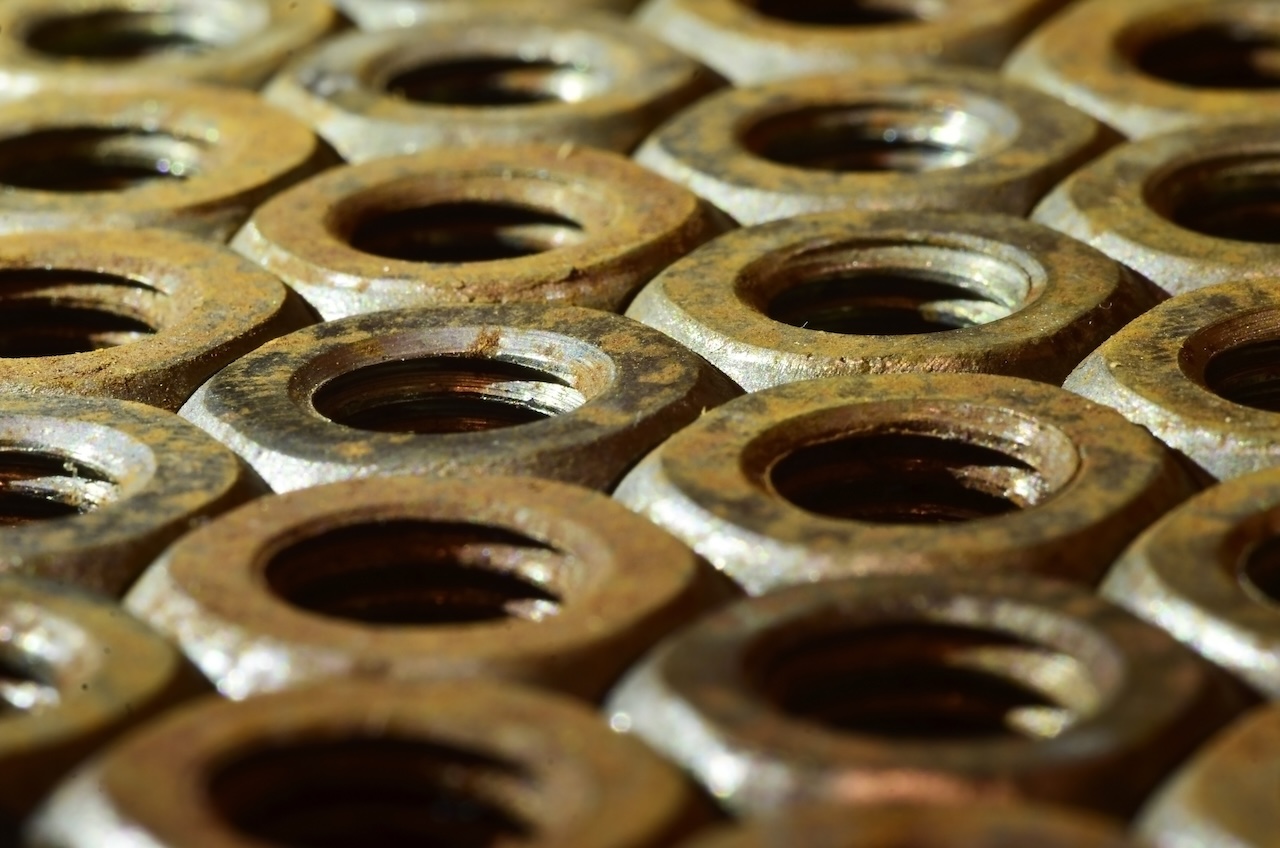 Closeup of a pile of rusty nuts. Retro industrial concept