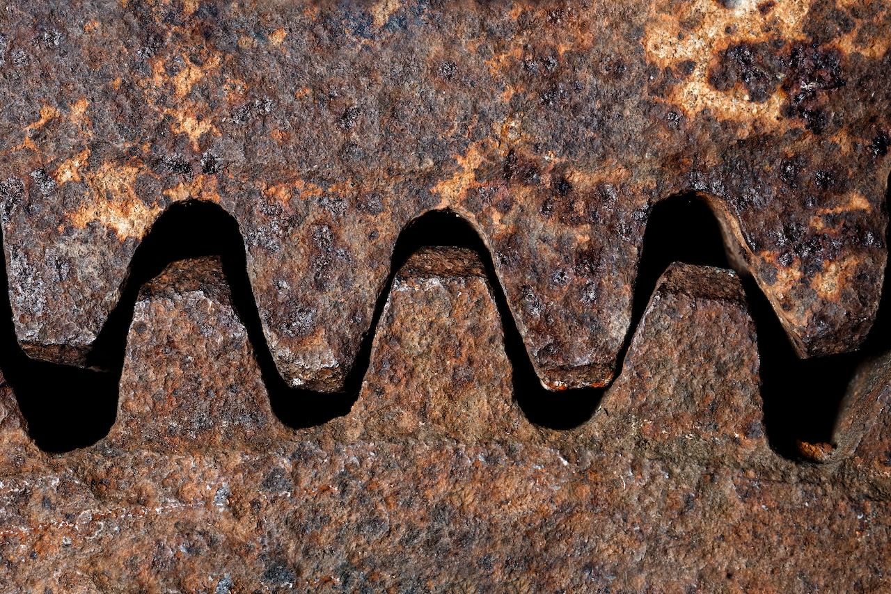 Backgrounds and textures: two connected steel cogwheels, very old and rusty, close-up shot, industrial abstract